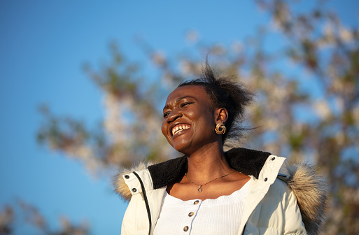 Young black girl is smiling on the outside at sunset.