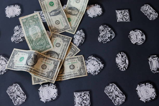 istock Dollars banknotes on a black background with diamonds 1527694141