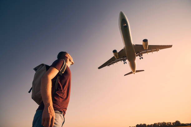 空港に着陸する飛行機を見上げる旅行者 - concepts airport ideas watching ストックフォトと画像