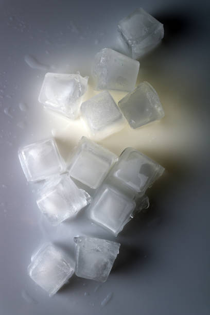istock ice cubes on white glass with a spot of warm light 1527746632