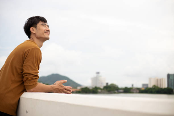 istock Smart Asian man relax on bridge with bright smile and positive thinking. 1527754423