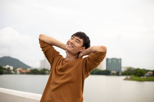 istock Smart Asian man relax on bridge with bright smile and positive thinking. 1527757545