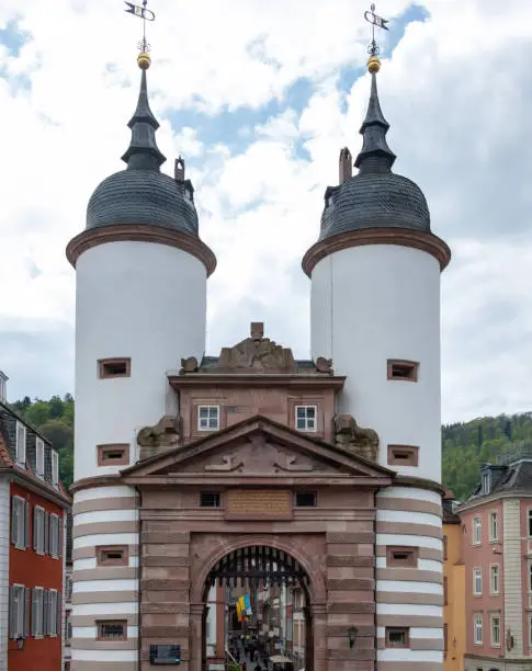 Photo of Germany, Heidelberg city. Old Bridge with large arched Gate between two white Tower. Vertical