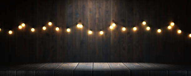 Empty wooden table in a bar or restaurant. Garland of colored light bulbs on the wall of a bar or restaurant, space for your task or message. 3d render. stock photo