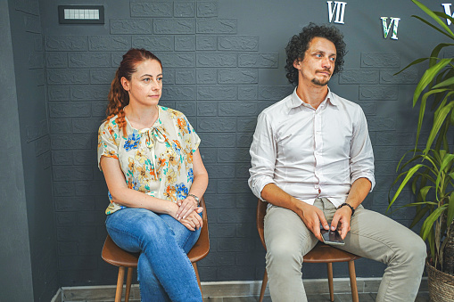 Man and woman sitting in the waiting room for a job interview