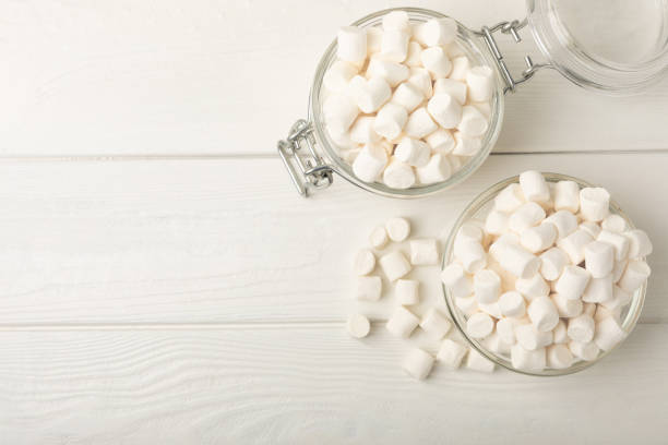 istock Many different marshmallows in bowls and jars on a white textured wood. White and fruit marshmallow. Sweets and snacks for a snack. Chewing candies close-up. Copy space. Place for text. 1527823837