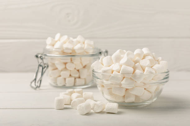 istock Many different marshmallows in bowls and jars on a white textured wood. White and fruit marshmallow. Sweets and snacks for a snack. Chewing candies close-up. Copy space. Place for text. 1527823838