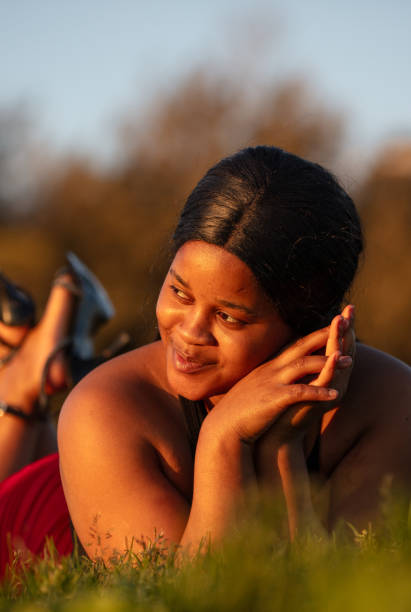 istock Young black woman is lying on the grass. 1527840946