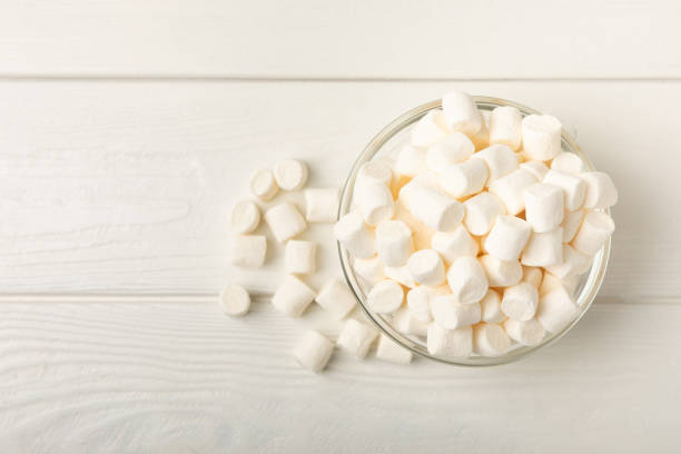 istock Many different marshmallows in bowls and jars on a white textured wood. White and fruit marshmallow. Sweets and snacks for a snack. Chewing candies close-up. Copy space. Place for text. 1527842626