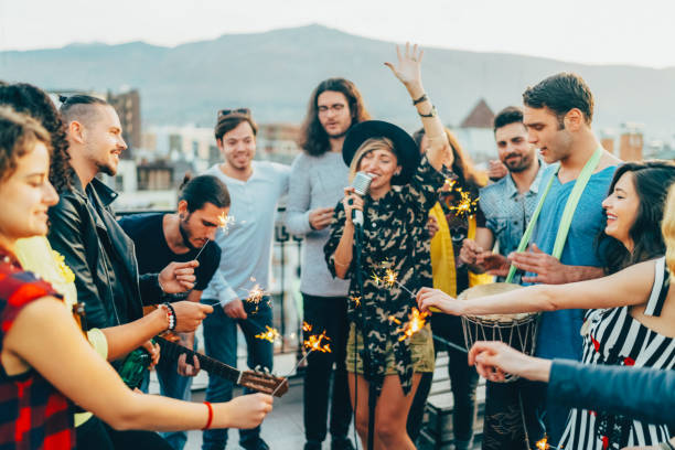 group of friends listening to live performance on rooftop party - individual event women people autumn imagens e fotografias de stock