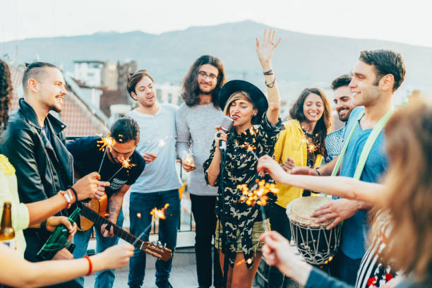 group of friends listening to live performance on rooftop party - individual event women people autumn imagens e fotografias de stock