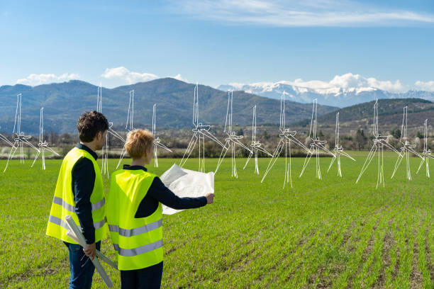 istock A line drawing of solar panels wind turbines while two architects look at plans in a remote location 1527906693