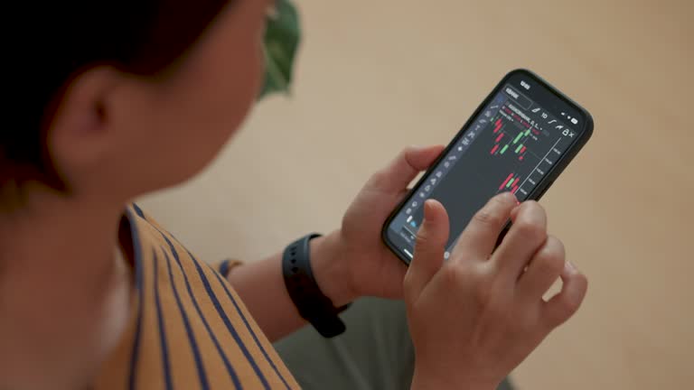 Close up shot of female hand analyzing and looking at diagrams on smart phone at living room.