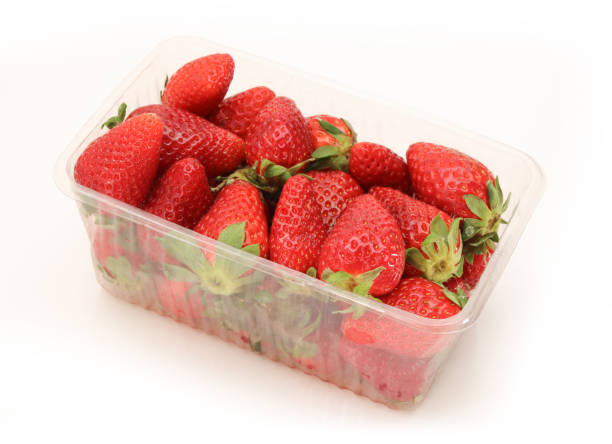 istock Plastic basket full of fresh strawberries isolated on white background 1527985847