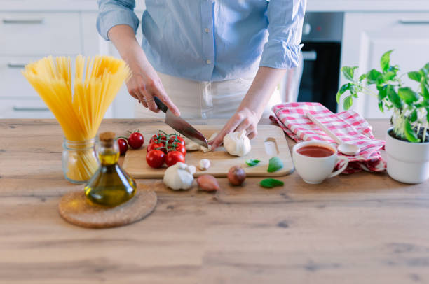 istock Young woman preparing tomato pasta at home kitchen 1527995407