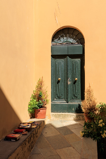 Street view in one of the villages in Val dOrcia national park. Wooden door, ivy climbing wall, pots with geranium, hydrangea. Stone wall