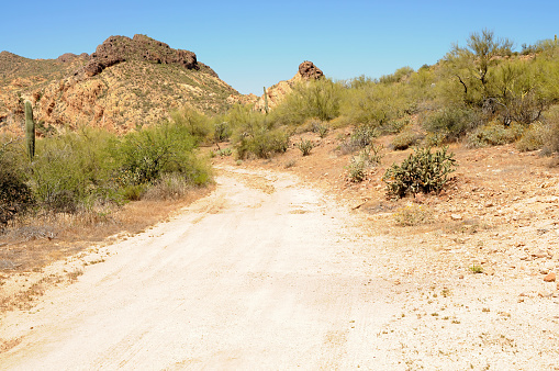 Dirt road leading off into the desert mountains of Arizona