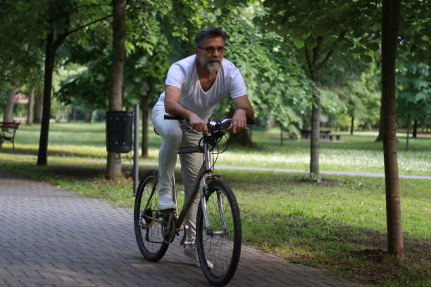 istock Active senior ride a bike in public park 1528054249