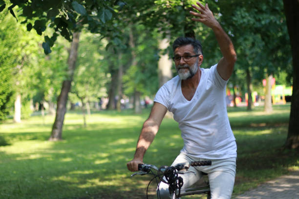 istock Active senior ride a bike in public park 1528055275