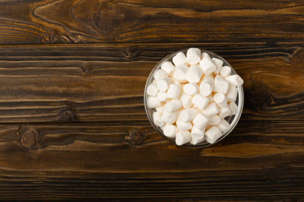 istock Many different marshmallows in bowls and jars on brown textured wood. White and fruit marshmallow. Sweets and snacks for a snack. Chewing candies close-up. Copy space. Place for text. 1528068292