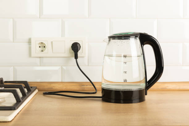 istock Modern electric transparent kettle on a wooden table in the kitchen.Kettle for boiling water and making tea.Home appliances for making hot drinks.Space for copy.Place for text. 1528069938