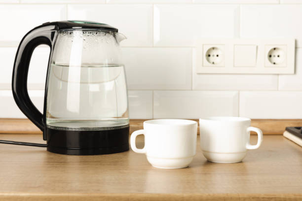 istock Modern electric transparent kettle on a wooden table in the kitchen.Kettle for boiling water and making tea.Home appliances for making hot drinks.Space for copy.Place for text. 1528069945