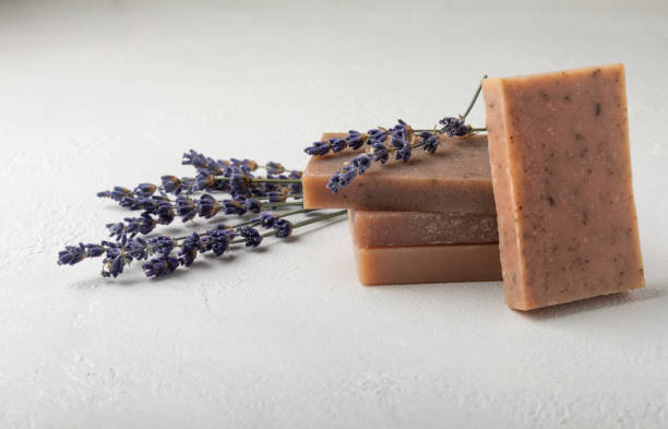 istock Natural soap with lavender extract. Handmade soap with lavender flowers on a white texture background. spa and relaxation concept.Aromatherapy.Flat lay.Place for text.Place for copy. 1528081364