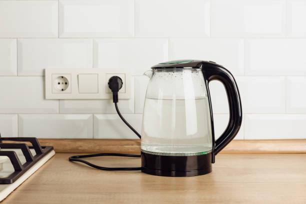 istock Modern electric transparent kettle on a wooden table in the kitchen.Kettle for boiling water and making tea.Home appliances for making hot drinks.Space for copy.Place for text. 1528082669