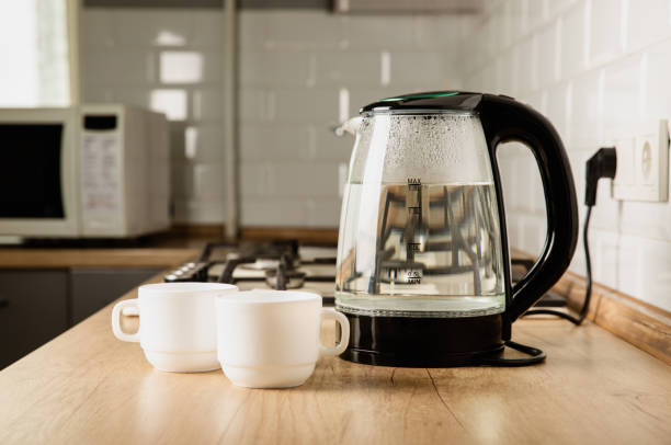 istock Modern electric transparent kettle on a wooden table in the kitchen.Kettle for boiling water and making tea.Home appliances for making hot drinks.Space for copy.Place for text. 1528082670