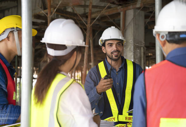 istock engineer project manager holding walkie talkie talking to work team on the building under construction 1528109490