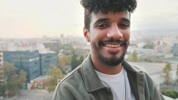 istock Close-up of smiling young guy posing at the camera while standing on the balcony 1528123363