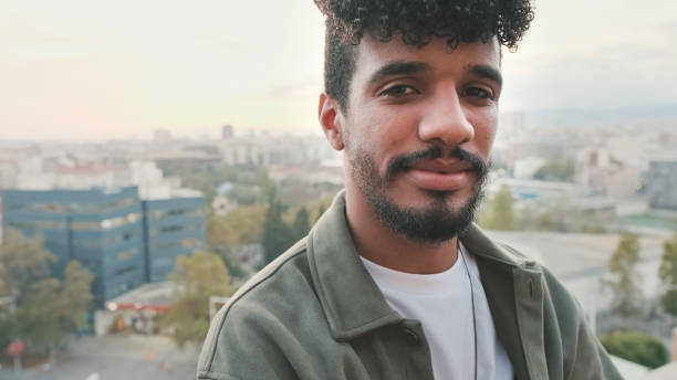 istock Close-up of smiling young guy posing at the camera while standing on the balcony 1528123367