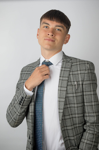 Young entrepreneur wearing a suit and tie adjusting his tie