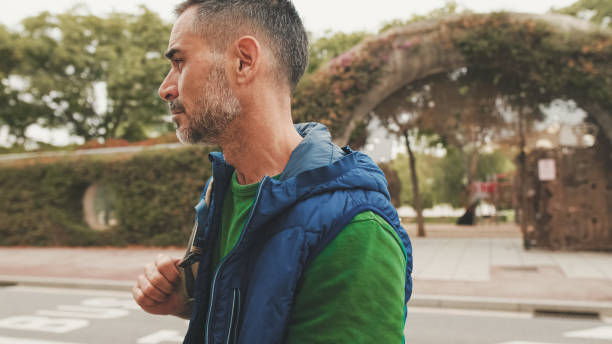 istock Mature man wearing casual clothes, with backpack on his shoulder, looks around 1528146165