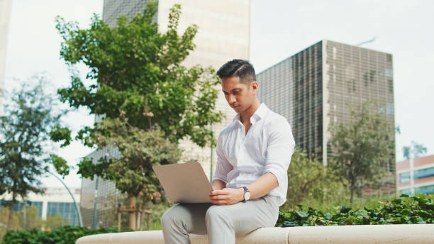 istock Young businessman using laptop while sitting next to business center 1528146172