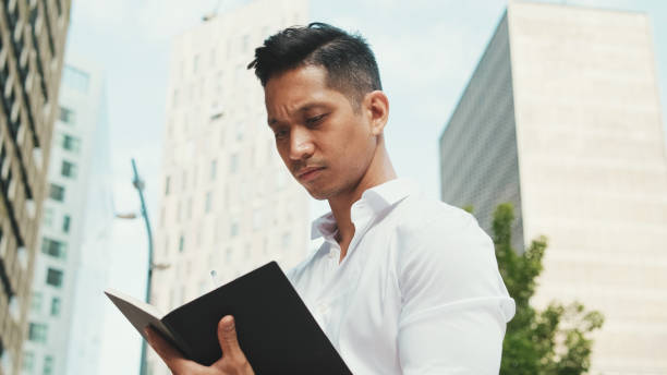 istock Close-up of young businessman making notes in personal paper planner 1528149865