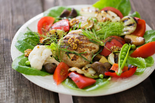 Grilled vegetables with mushrooms, meat and greens on a plate