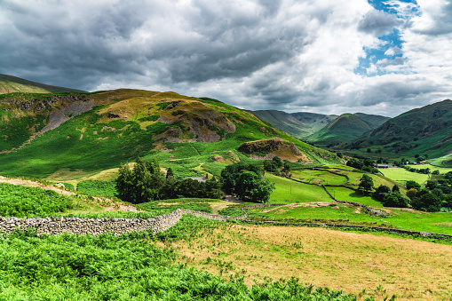 A seat with a view.  Wooden bench overlooking Arkengarthdale in Swaledale, North Yorkshire.  Summertime in the Yorkshire Dales fwith blue sky and lush green fields.  Horizontal.  Space for copy.