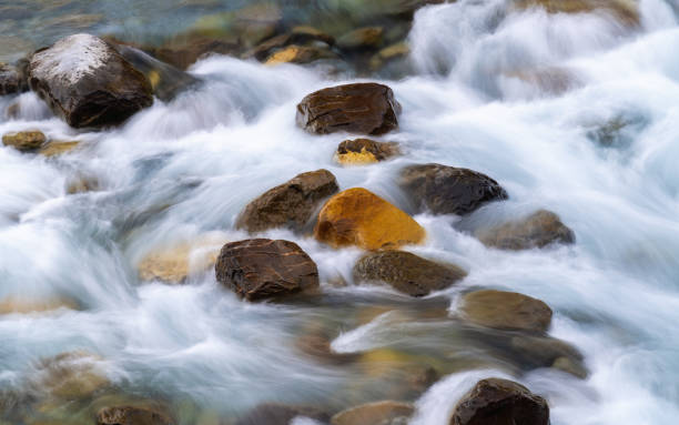 istock long exposure Water flowing by the river rocks 1528285679