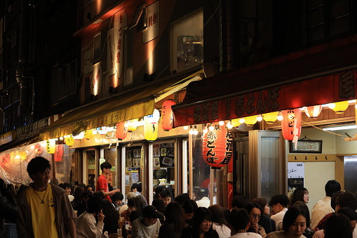 Tokyo -May 4 2023: visitors enjoy the street food after work at hobby street at night. one of restaurant street in midnight