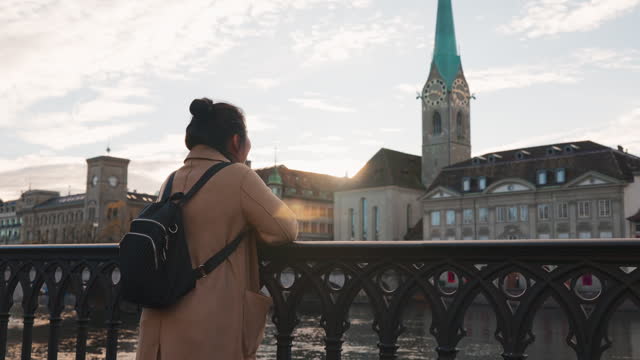 enjoy sight seeing famous city of Zurich Switzerland street and architecture walking street sunset vacation travel lifestyle,Asian woman using smartphone while walking in Zurich Switzerland