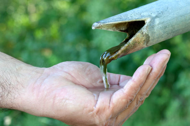 Only a little water flows from the water fountain into the human hand. A drop in the water table threatens the water supply of billions of people around the world.