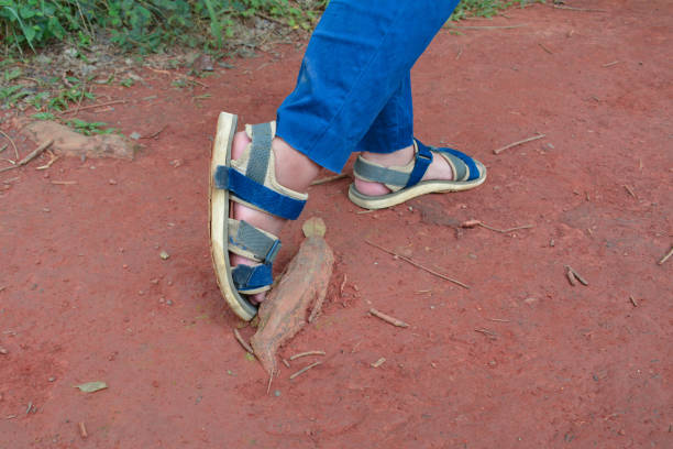 Men's feet in sandals on a grey grunge tiled background