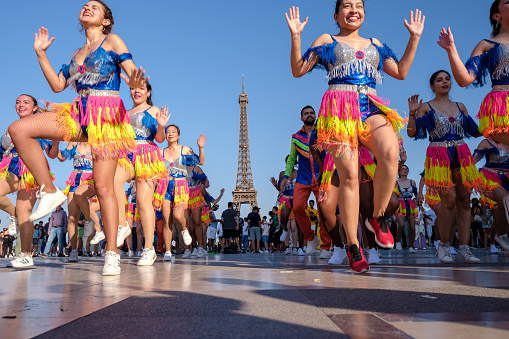Paris, France - June 25, 2023 : Young Colombian dancers with beautiful costumes perform a Latin style dance in front of the Eiffel Tower in Paris France