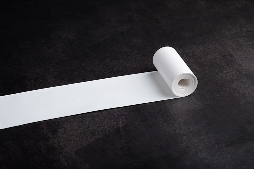 Long white paper roll on black background