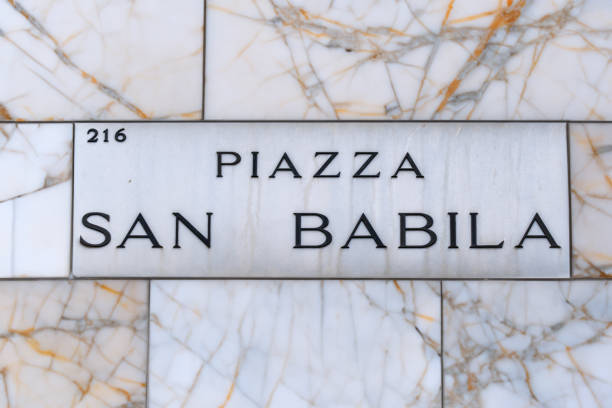 On marble wall the sign pointing to Piazza san Babila, famous square in the center of Milan,bustling home of stores, offices, monuments.