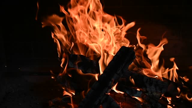 Burning fire in the brick fireplace, close up.