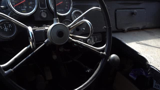 The steering wheel of a retro car, the interior of a vintage car, an abandoned car interior