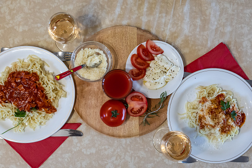 Making a fresh delicious Italian pasta, spaghetti with tomato sauce, garlic, basil and spices