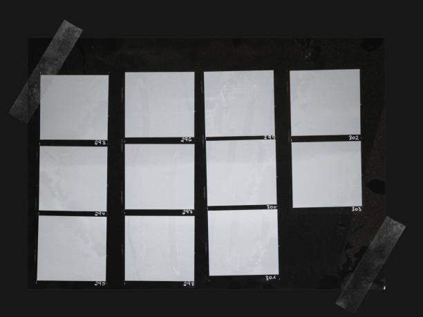 ręczne kopiowanie arkusza papieru średnioformatowego z pustymi ramkami utrwalonymi przezroczystą taśmą klejącą na czarnym tle - medium format camera obrazy zdjęcia i obrazy z banku zdjęć